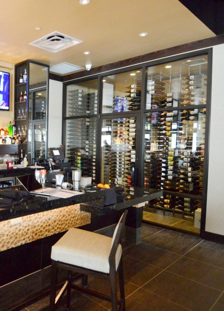 This contemporary commercial custom wine cellar in Phoenix, Arizona, displays the wines in metal wine racks.