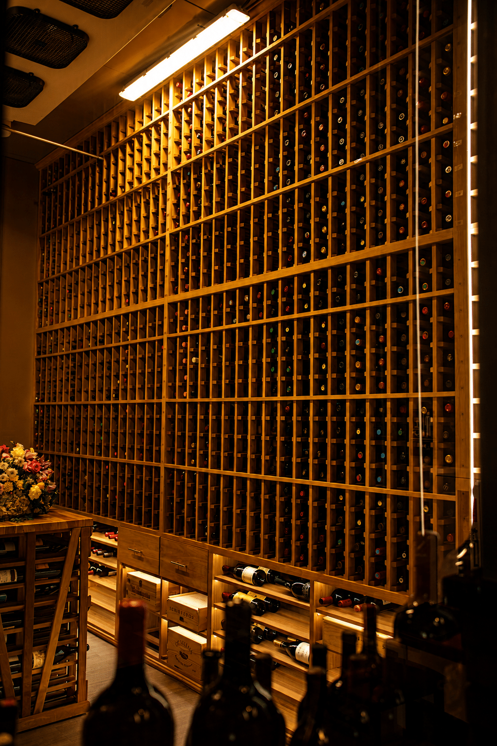 Mahogany wine racking with individual bottle compartments, integrated drawers, and horizontal storage at the base.