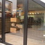 This under stair wine cellar is enclosed by custom fit glass walls and door.