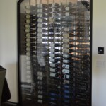 Label forward metal wine racking behind a glass wall is a beautiful and dynamic conversation piece in this Arizona home.