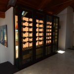 The LED lighting in this modern wine closet can be brightened to show up during the day and darkened at night to suit any mood.